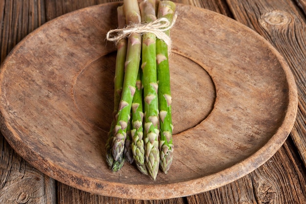 Fresche lance di asparagi su un tavolo di legno