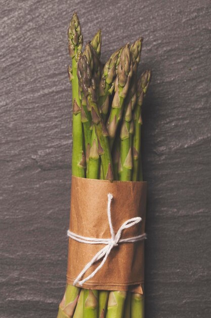 Fresh asparagus tied in a bunch on a rustic slate background