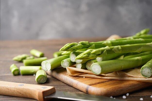 Asparagi freschi su una superficie di legno e grigia, primo piano