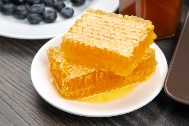 写真 木製の背景に新鮮な蜂蜜とブルーベリーの盛り合わせ健康的な有機ビタミン食品
