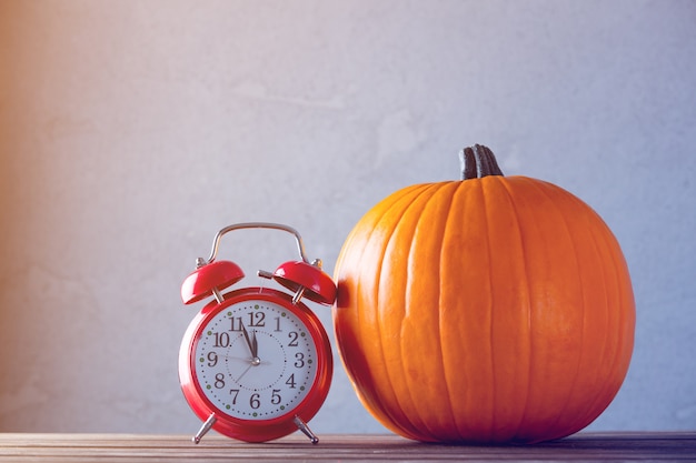 Fresh Autumn pumpkin and retro alarm clock