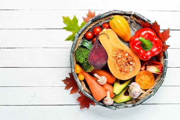 Fresh autumn vegetables on white wooden background Healthy food