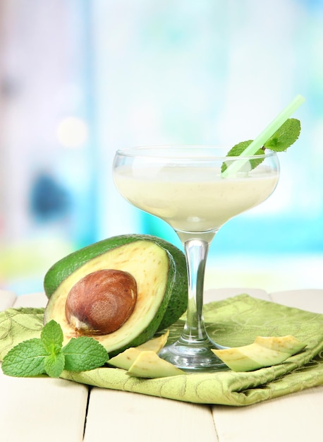 Fresh avocado smoothie on bright background