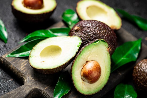 fresh avocado with foliage on a cutting board