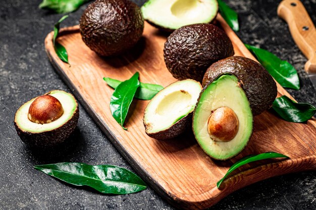 Fresh avocado with foliage on a cutting board