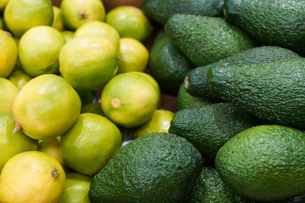 Fresh avocados and limes on the table in the market