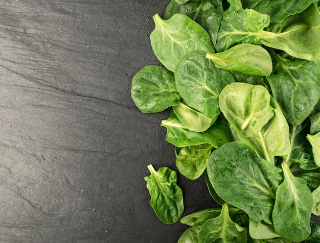 Fresh baby spinach leaves on a wooden table