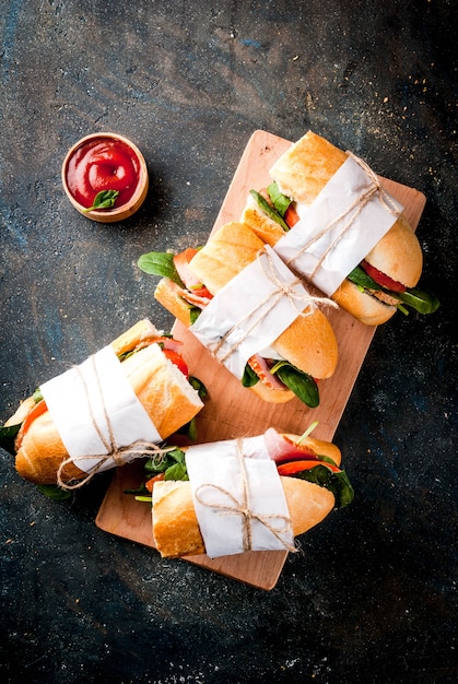 Fresh baguette sandwich with bacon, cheese, tomatoes and spinach