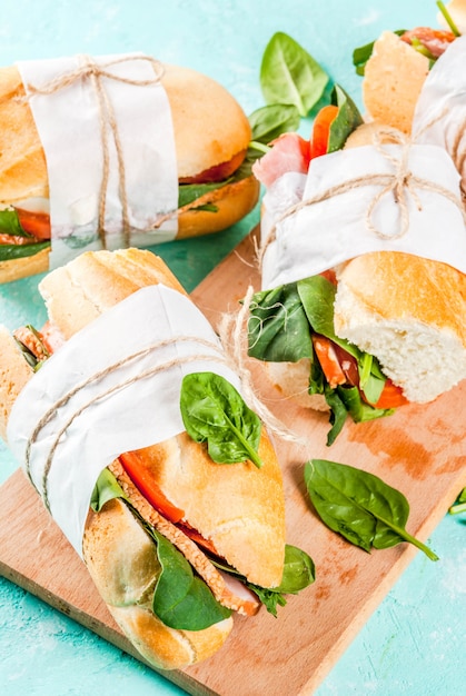 Fresh baguette sandwich with bacon, cheese, tomatoes and spinach