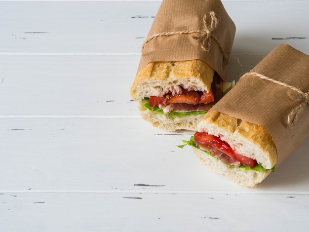 Fresh baguette sandwich with meat, sliced cheese, tomatoes and fresh lettuce