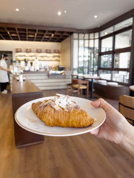 Fresh baked almond croissant and coffee breakfast