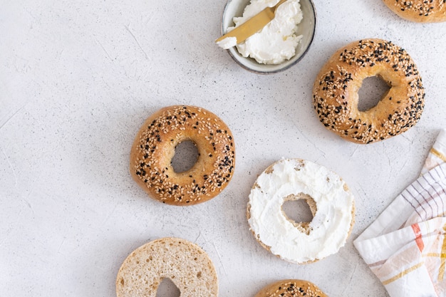 Bagel al forno freschi con formaggio di filadelfia sul tavolo luminoso