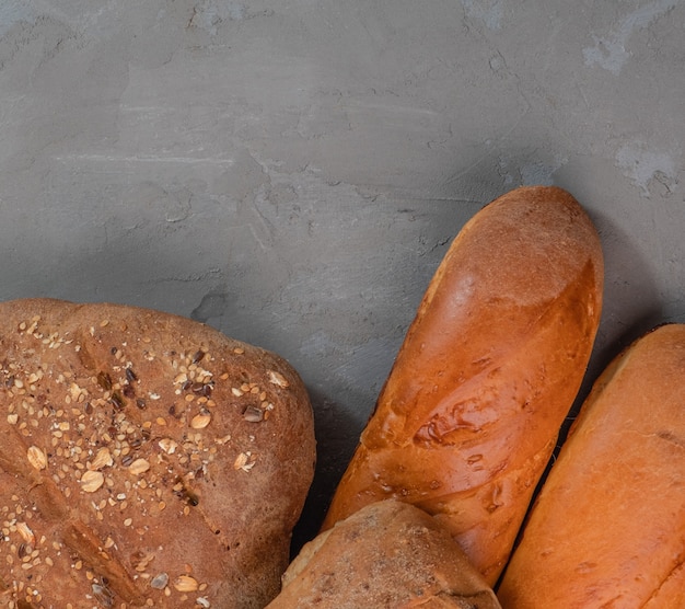 Fresh baked baguettes and bread on a gray background with free space for text.