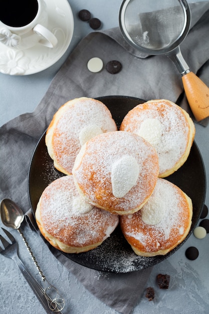 Fresh baked berliner with custard on a gray concrete 