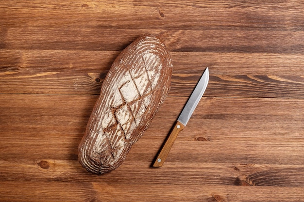 Свежий испеченный хлеб на коричневом деревянном столе коричневый хлеб грубого помола