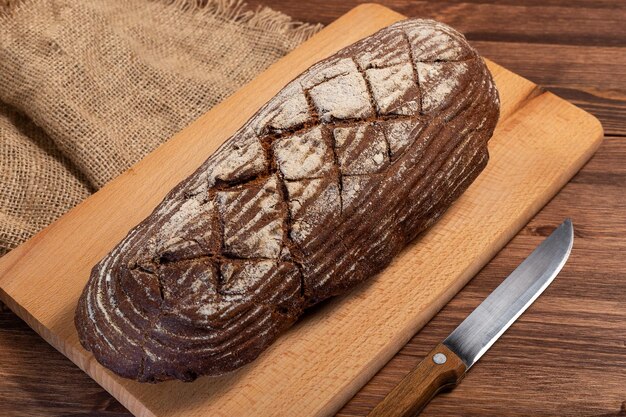 Fresh baked bread at brown wooden table brown coarse grain bread