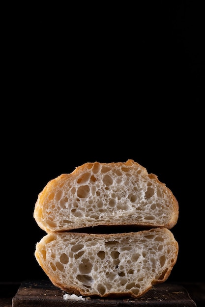 Fresh Baked Bread Cut in Half on a black background