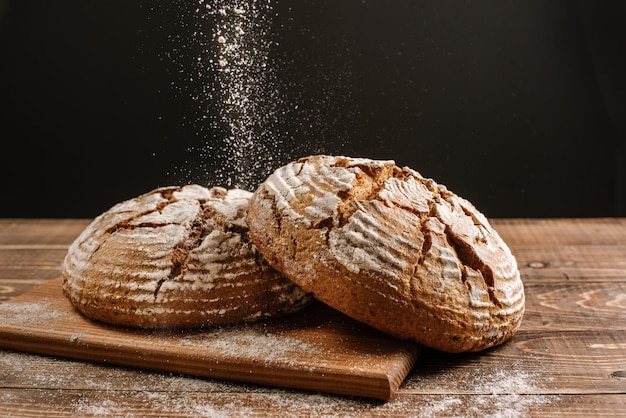 Pagnotte di pane appena sfornato sullo sfondo di legno