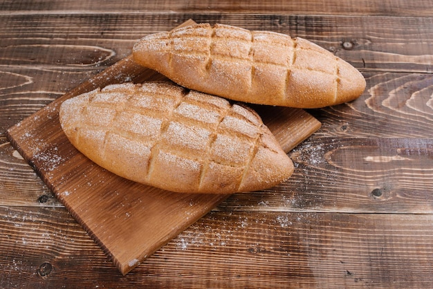 Fresh baked bread loafs on the wooden background