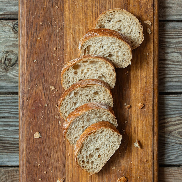 木製の背景に新鮮に焼いた小麦の全粒パン