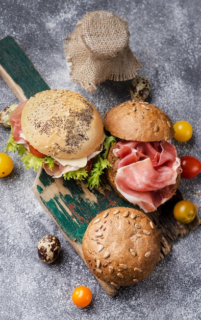 Fresh baked burger buns on a vintage wooden board