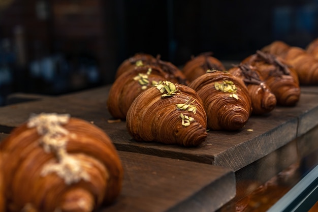 fresh baked croissants in glass showcase of little restaurant