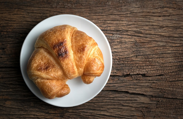 Fresh baked croissants on wood table from above