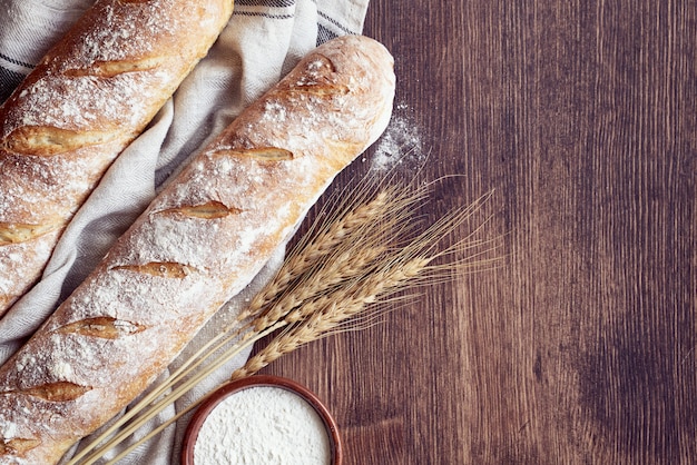 Fresh baked homemade crusty bread baguette. Two loaves on linen towel