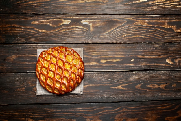 Fresh baked organic classic American apple pie on wooden table.