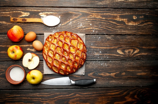 Fresh baked organic classic American apple pie on wooden table.