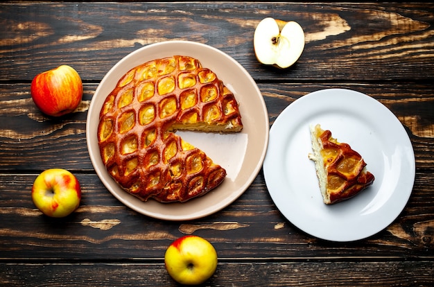 Fresh baked organic classic American apple pie on wooden table.