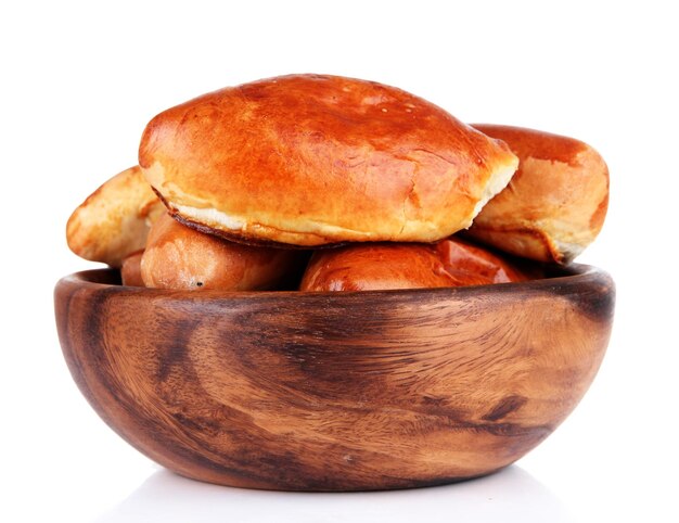 Fresh baked pasties in wooden bowl isolated on white