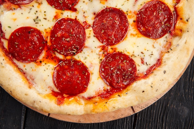 Fresh baked peperoni pizza on the wooden table