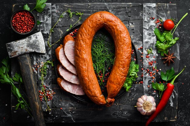 Fresh baked sausage Salami on a black stone background Top view Free space for text