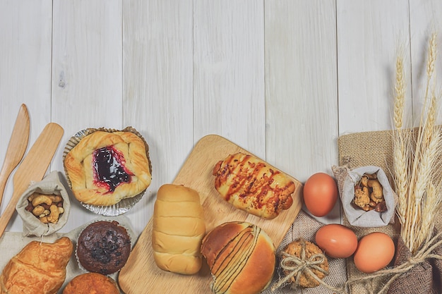 Il forno fresco ha cotto il pane delizioso su di legno bianco