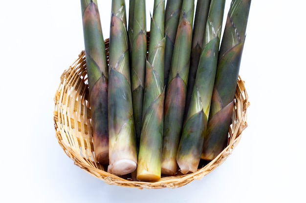 Fresh bamboo shoots in bamboo basket on white background.