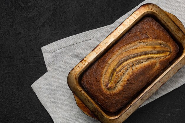 Pane fresco alla banana di forma rettangolare su tovagliolo in tessuto e sfondo nero