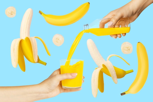 Свежий банановый сок наливают из бутылки в стеклянные женские руки Летающие бананы ломтиками банана на синем фоне Концепция