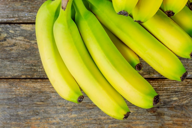 Banane fresche un mazzo su fondo di legno