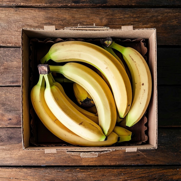Свежие бананы в старой коробке на деревянном столе