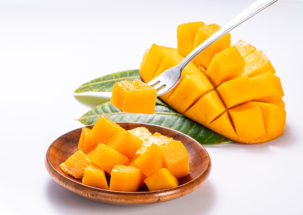 Fresh and beautiful mango in a wooden plate with sliced diced mango chunks isolated with white background, copy space(text space), blank for text