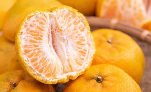 Fresh beautiful orange color tangerine on bamboo sieve over dark wooden table seasonal traditional fruit of chinese lunar new year close up