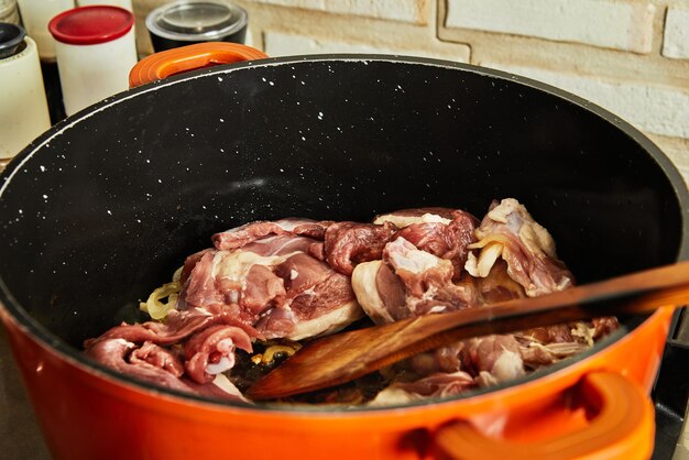 写真 新鮮な牛肉をガスストーブの鍋で玉ねぎと一緒に揚げる