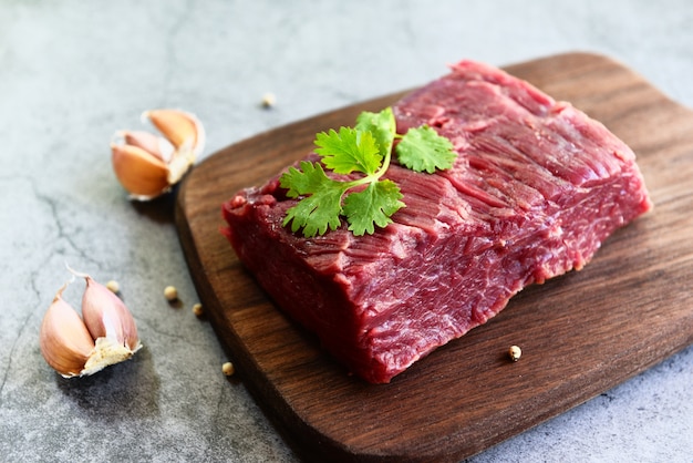 Fresh beef piece for steak or grilled barbecue  Raw meat beef steak with spices garlic on wooden cutting board and black 