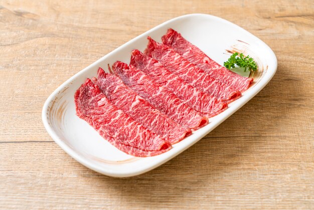 霜降りのテクスチャーでスライスした生の新鮮な牛肉