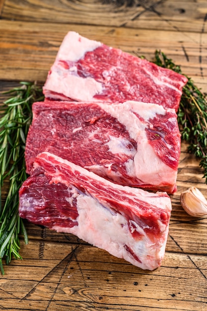 Fresh Beef short ribs on butcher wooden table. Wooden background. Top view.