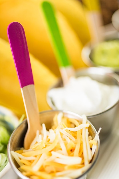 Fresh beef tacos in hard yellow corn taco shell with sour cream and shredded cheese.