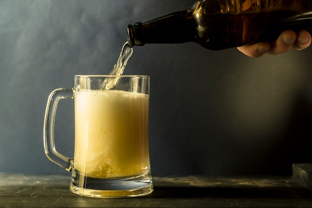 Fresh beer is poured from the bottle into the mug