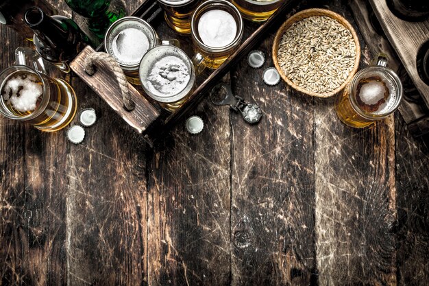 Foto birra fresca con luppolo verde e malto. su un tavolo di legno.