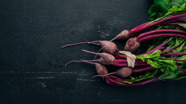 Fresh beetroot with green leaves on a wooden background top view copy space